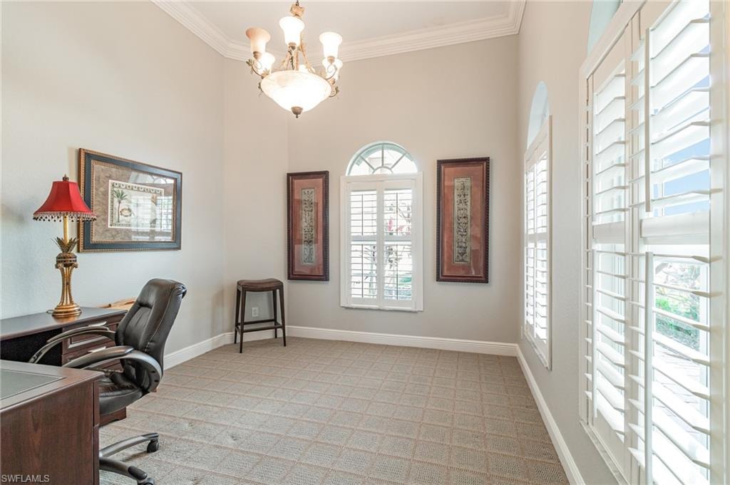 Office space with crown molding, a chandelier, and light colored carpet