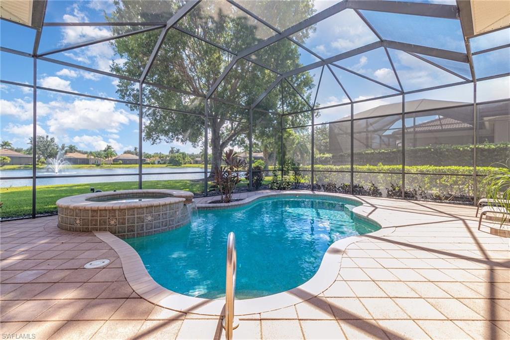 View of swimming pool with a water view, a lanai, a sunroom, and a pool with connected hot tub