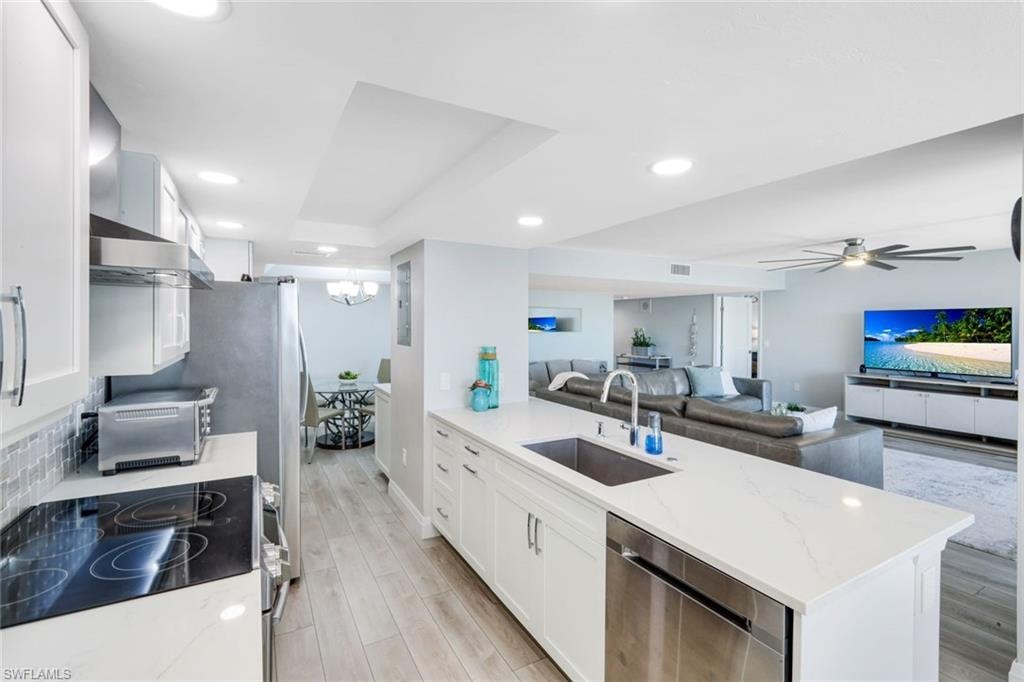 Kitchen with white cabinets, range with electric cooktop, a peninsula, dishwasher, and recessed lighting