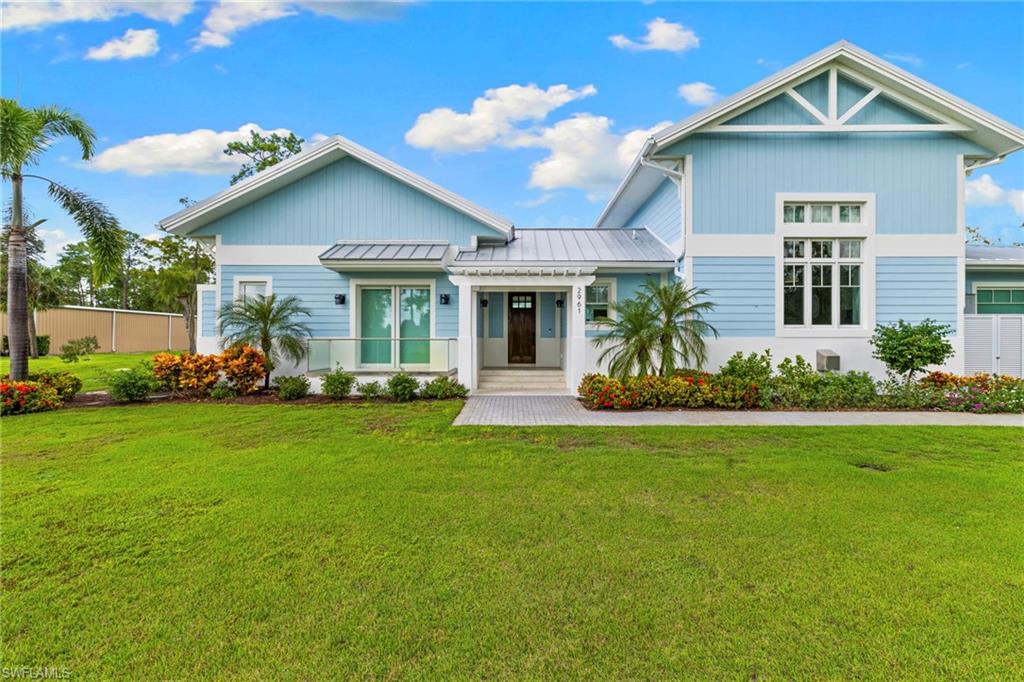 View of front of property featuring a front lawn, a standing seam roof, and a metal roof