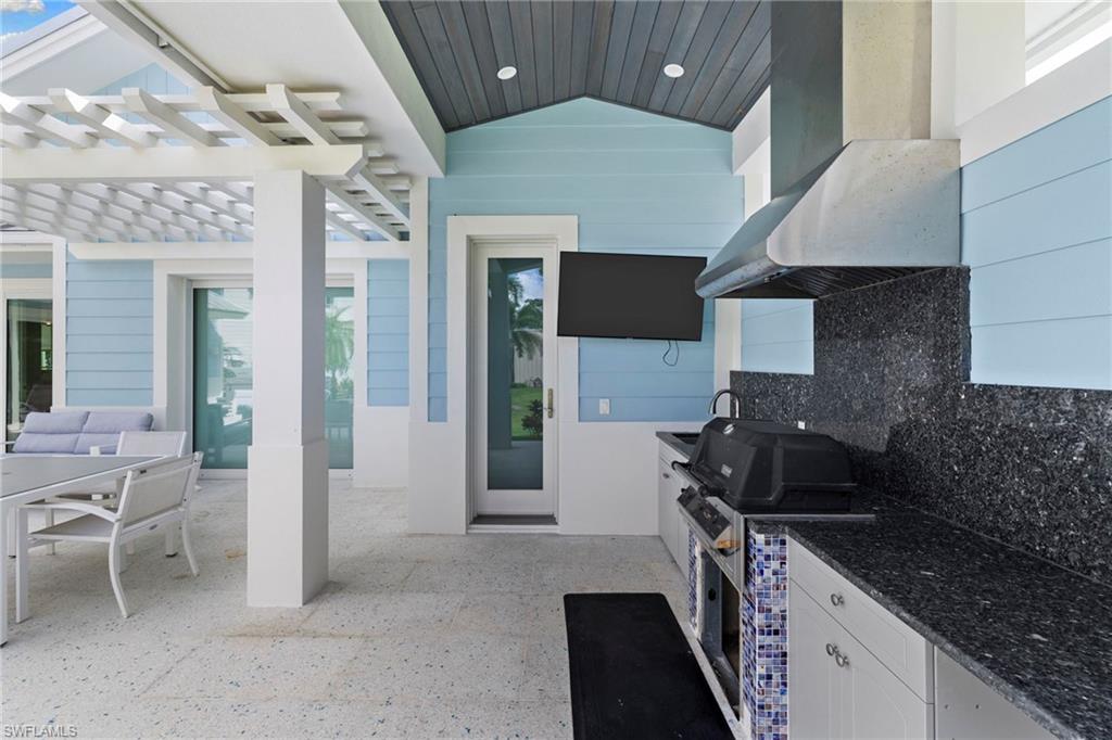 View of patio / terrace featuring an outdoor kitchen, a pergola, and outdoor dining space