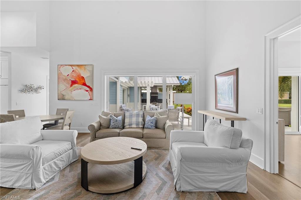 Living room with a towering ceiling, wood finished floors, and healthy amount of natural light
