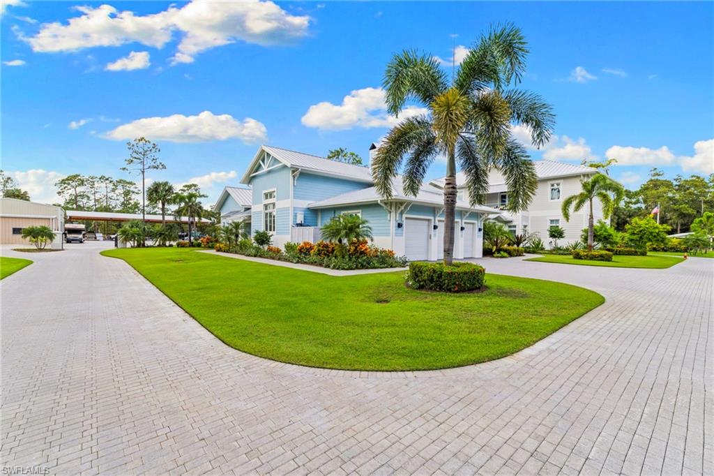 View of front of home featuring a front yard and curved driveway