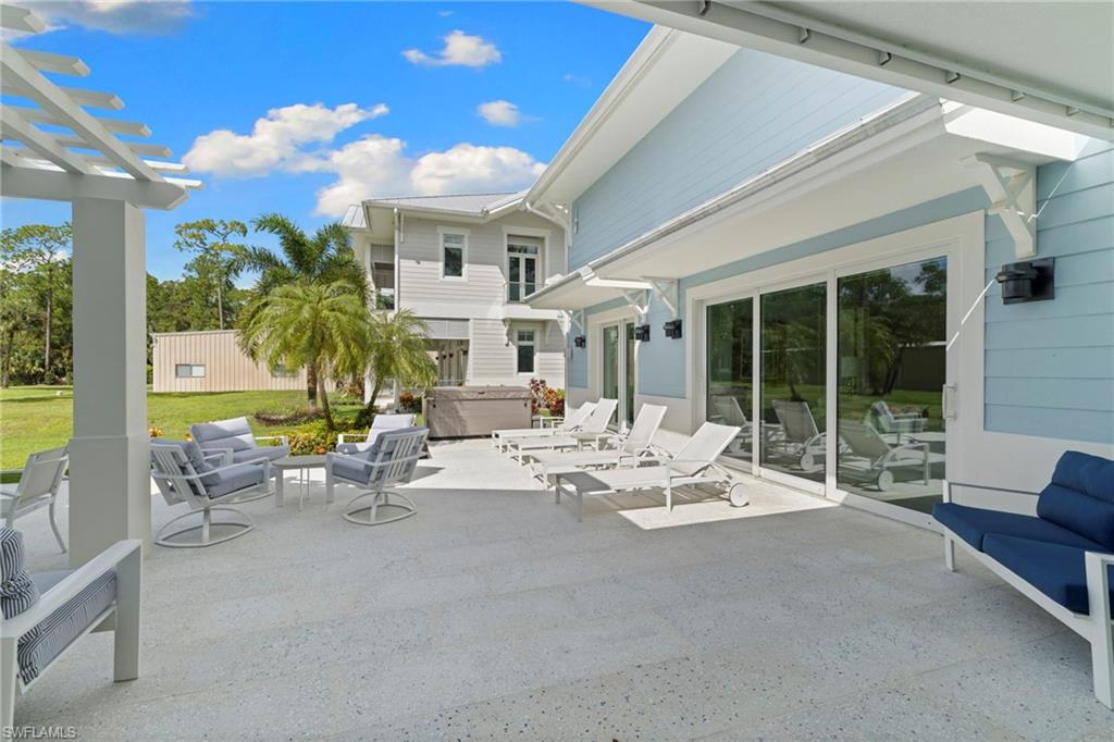 View of patio / terrace with a hot tub, an outdoor hangout area, and a pergola