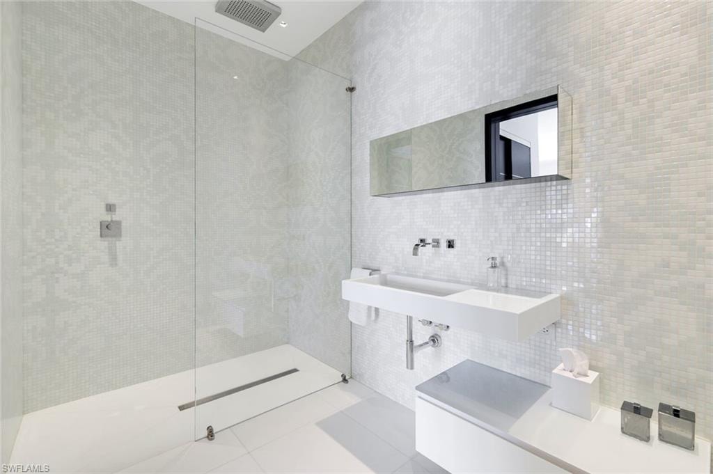 Full bath featuring tile walls, walk in shower, and tile patterned floors