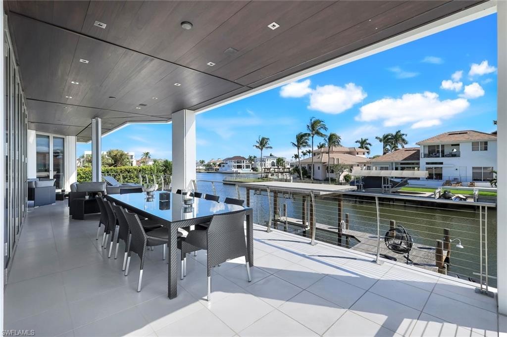 View of patio / terrace with outdoor dining area, a water view, and a residential view