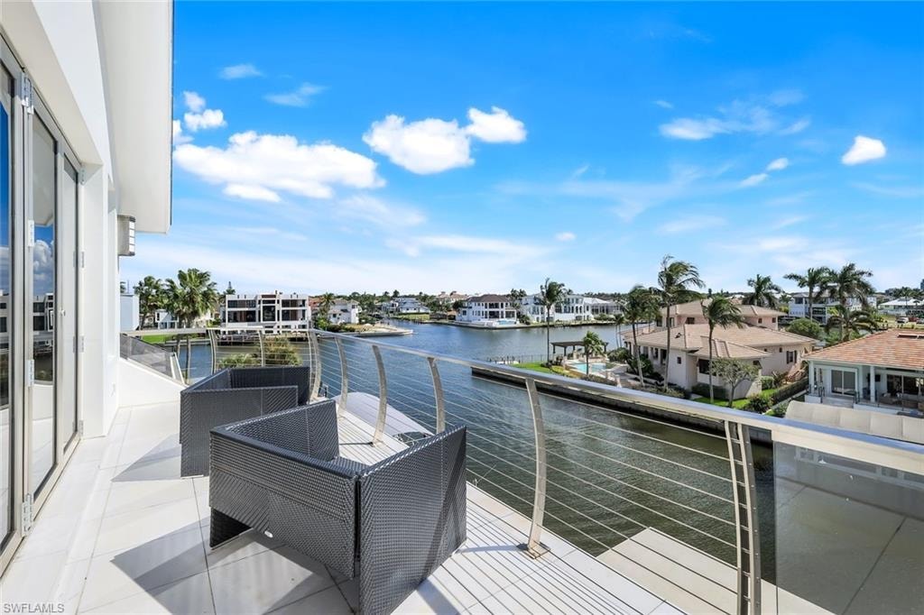 South-facing balcony with Thassos marble tile, stainless-steel railings, and panoramic bay views.