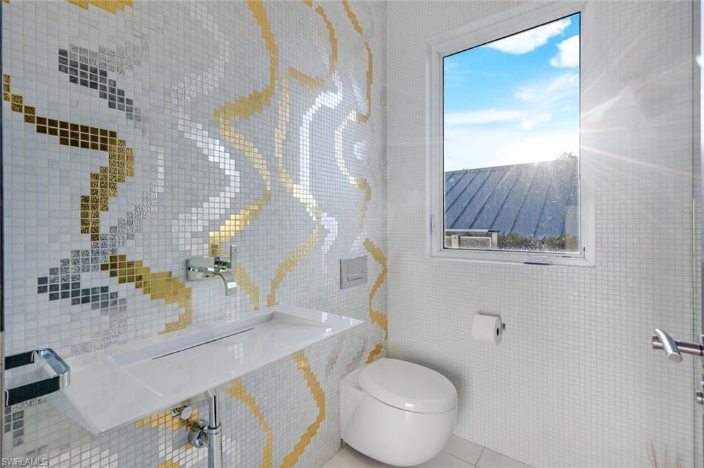 Elegant half bath with Bisazza gold leaf mosaic tile and premium Dornbracht fixtures