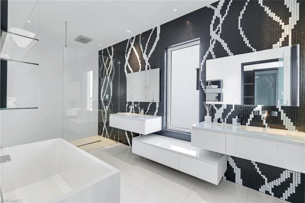 Full bath featuring a bathtub, a walk in shower, light tile patterned floors, two vanities, and pet washing area
