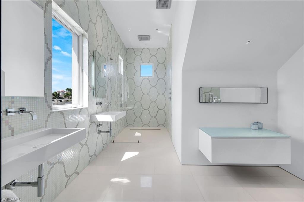 Full bathroom featuring tile walls, light tile patterned floors, and a marble finish shower