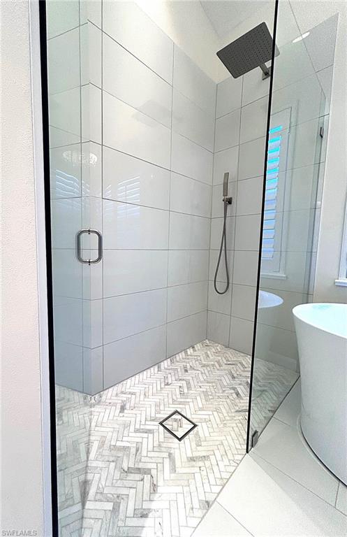 Bathroom with a shower stall and a freestanding bath