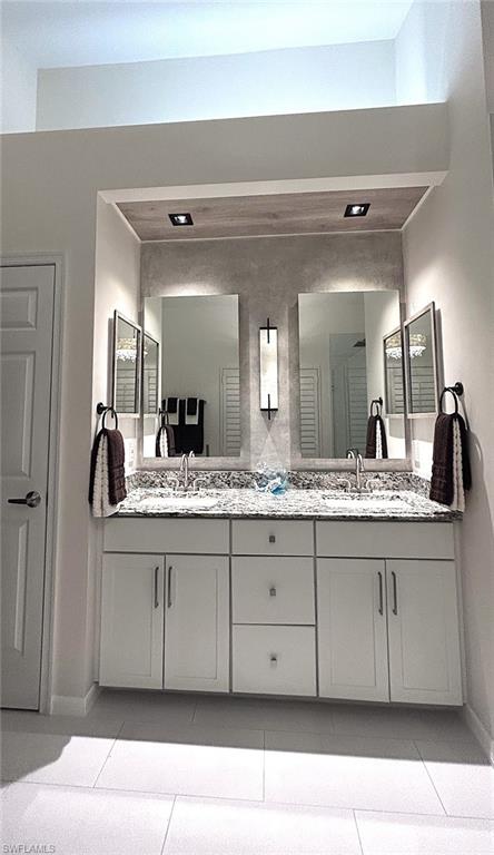 Full bathroom featuring double vanity and baseboards