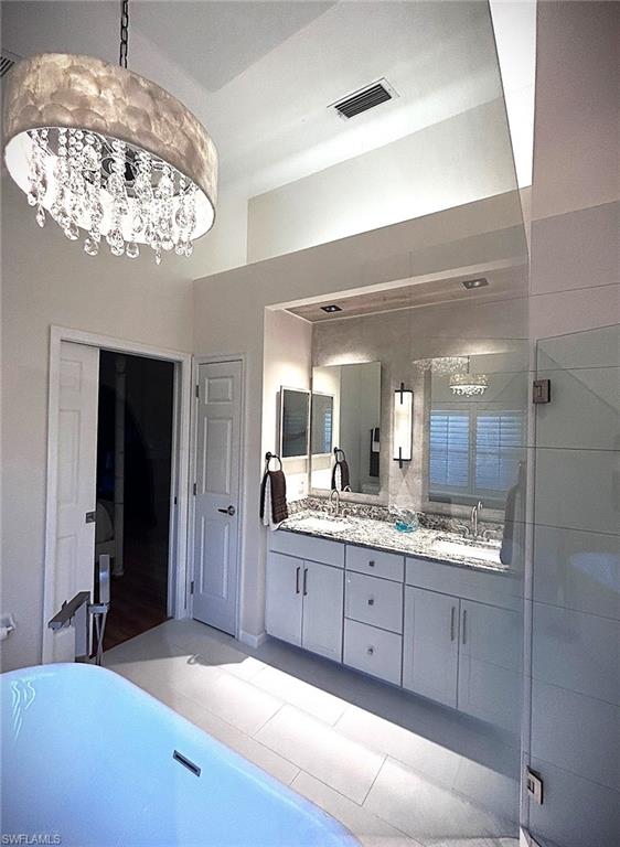 Bathroom featuring double vanity and a soaking tub