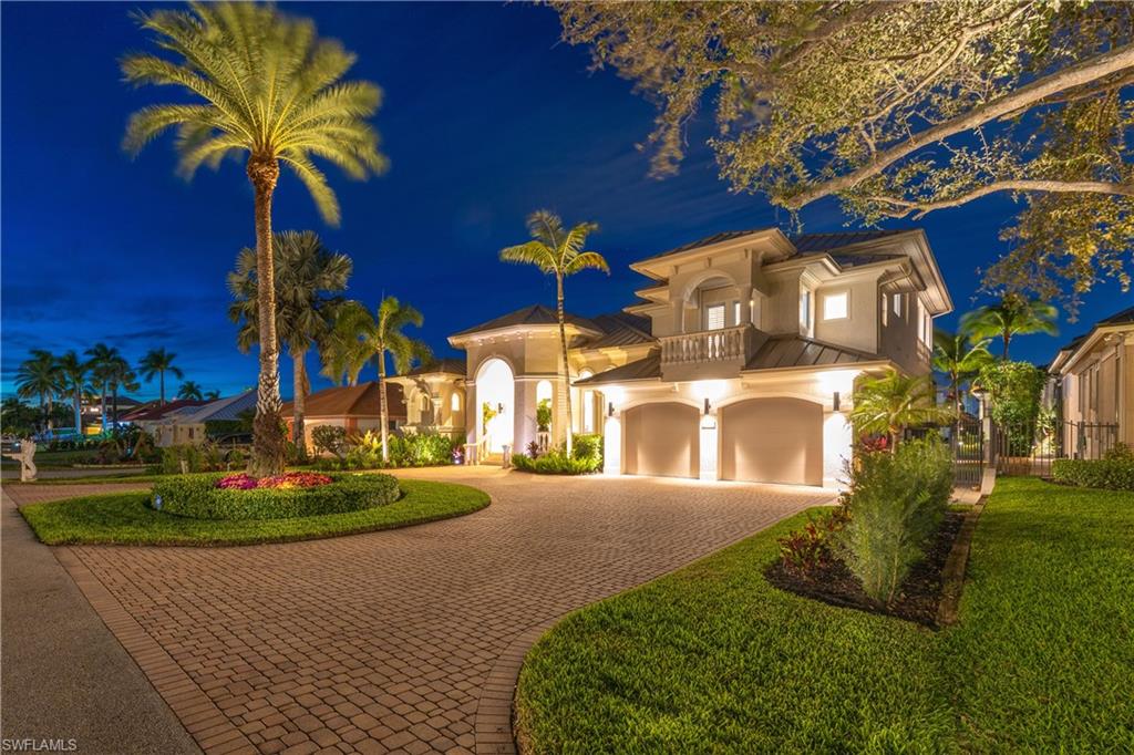 The home has great curb appeal, with a large circular paver driveway, and is beautifully lit and landscaped