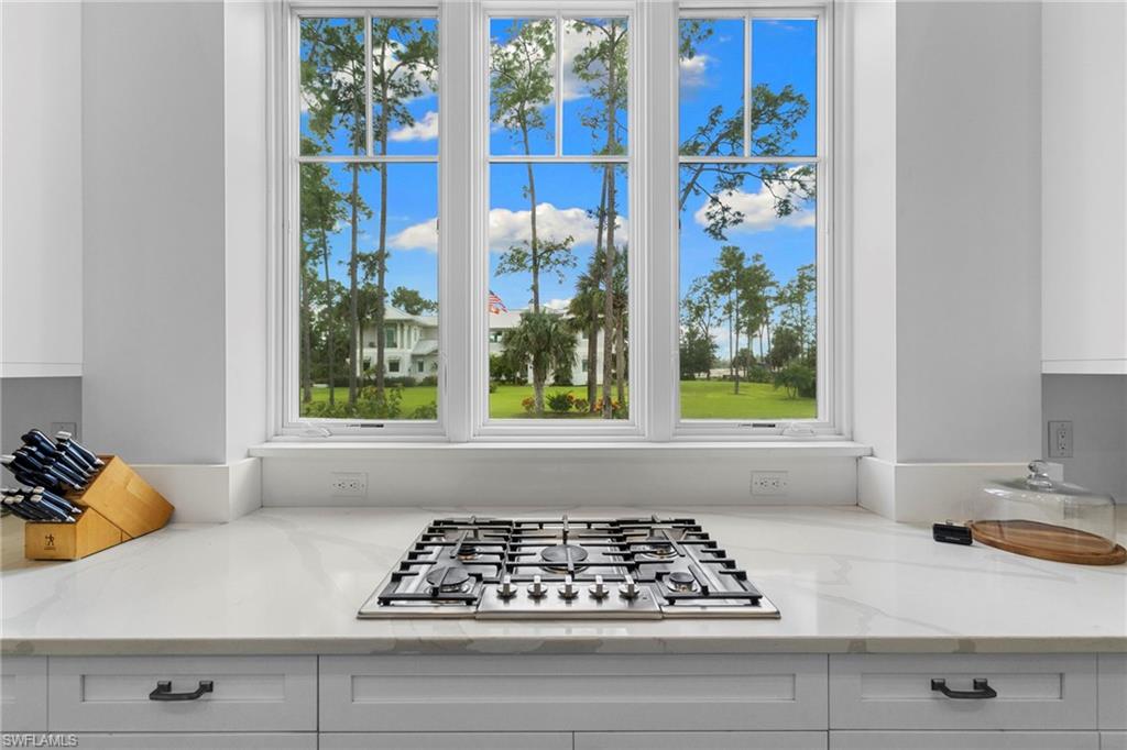 Kitchen view of white cabinets, light stone counters, and stainless steel gas cooktop