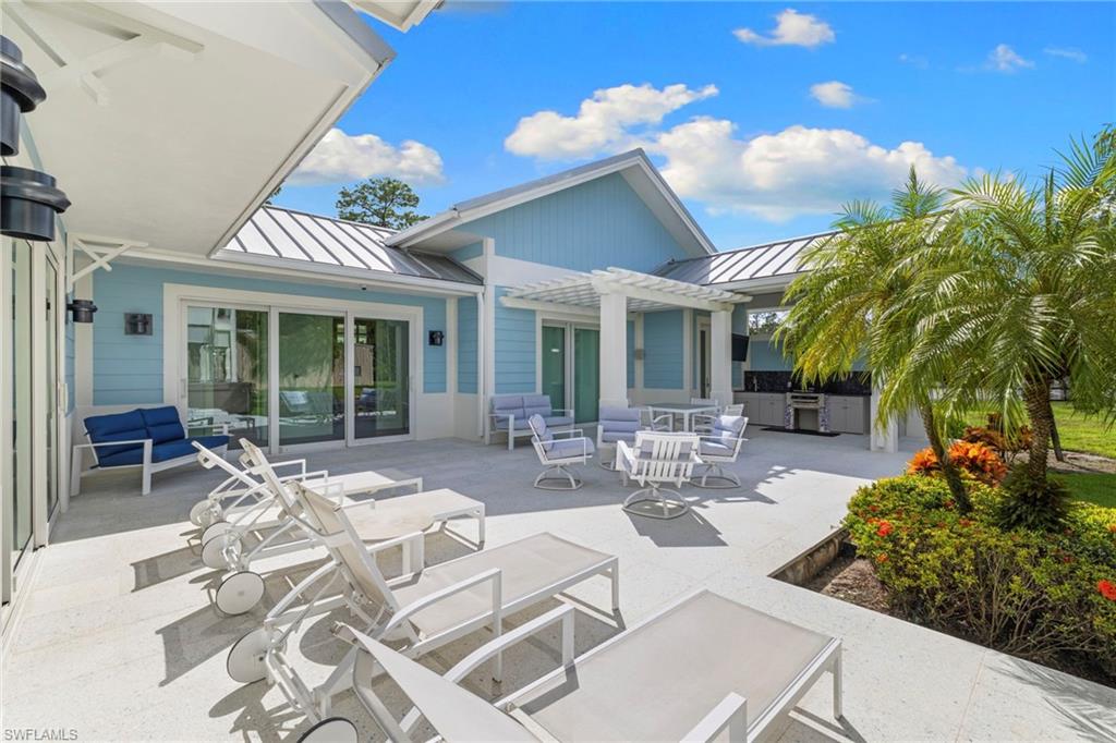Back of house with a standing seam roof, a metal roof, a patio, area for grilling, and an outdoor hangout area