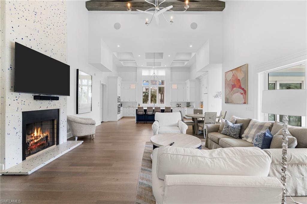 Living area featuring a chandelier, dark wood finished floors, a premium fireplace, and a high ceiling