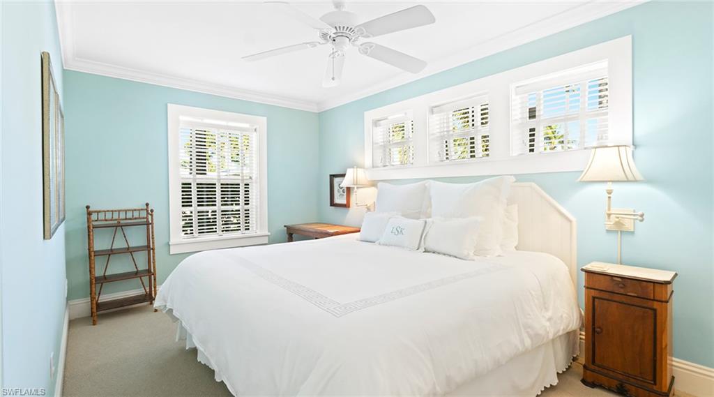 Bedroom with crown molding, ceiling fan, and carpet