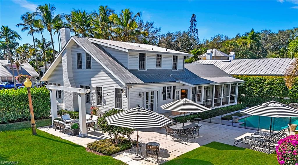 Back of property with a patio area, a sunroom, a yard, and a chimney