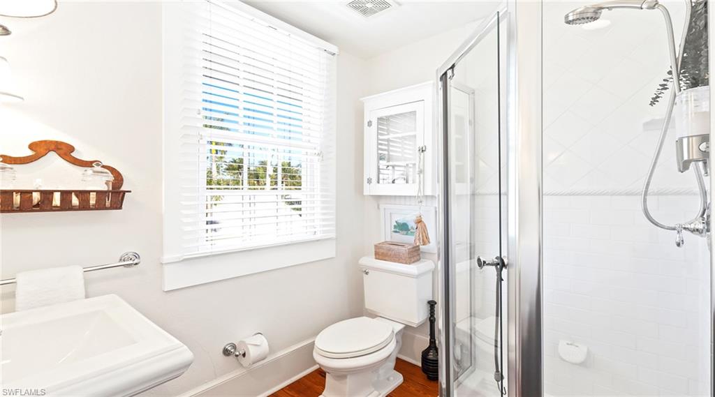 Full bathroom with a shower stall and dark wood-style flooring