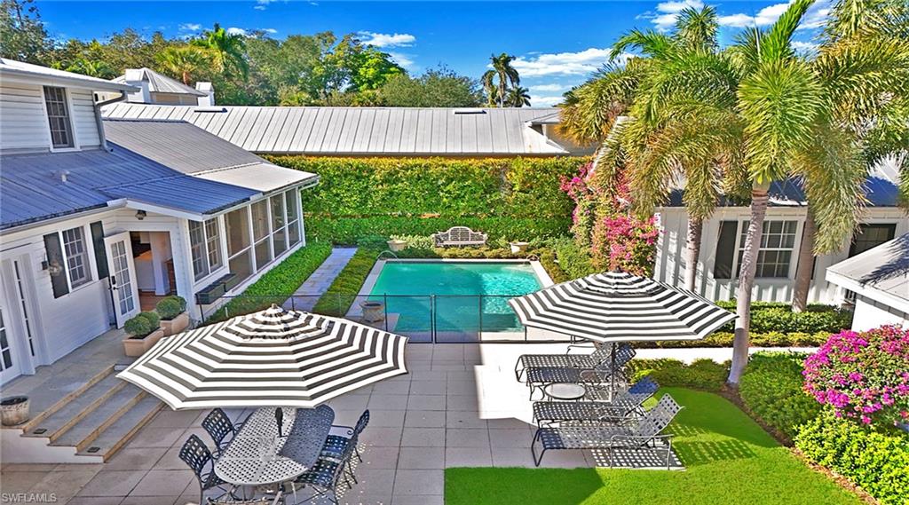 Outdoor pool featuring a sunroom, a patio area, and outdoor dining space