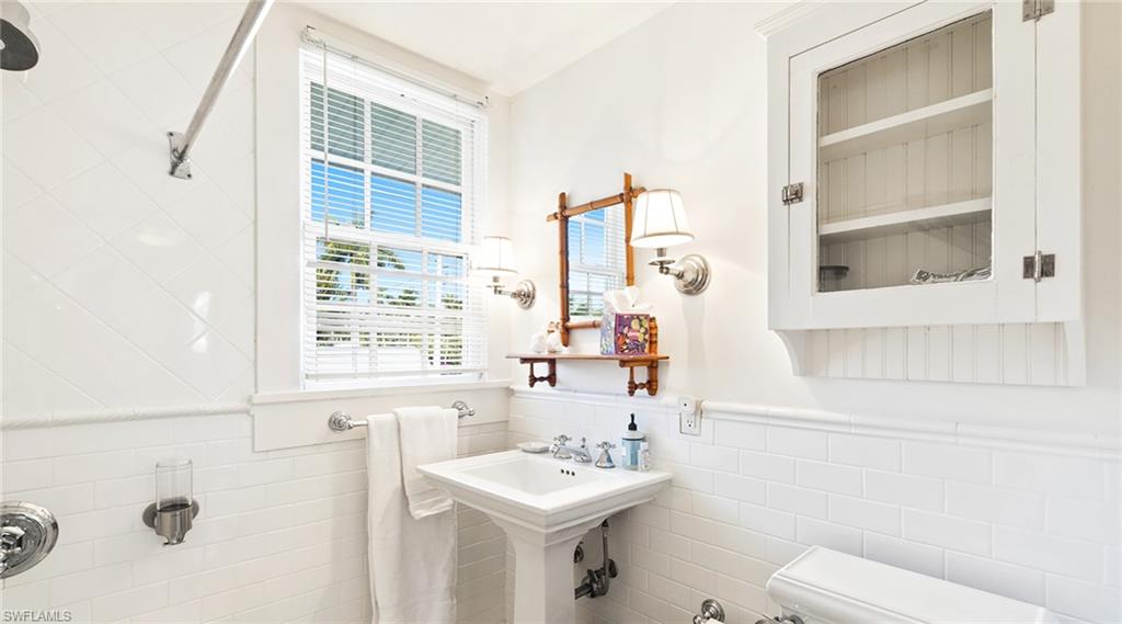 Bathroom with tile walls and a wainscoted wall