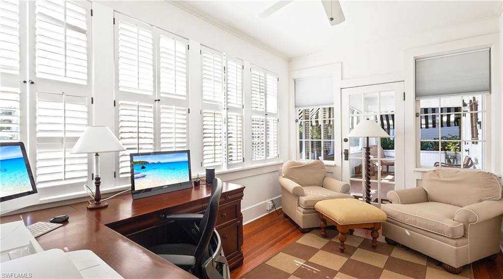 Office space with wood finished floors, crown molding, and ceiling fan