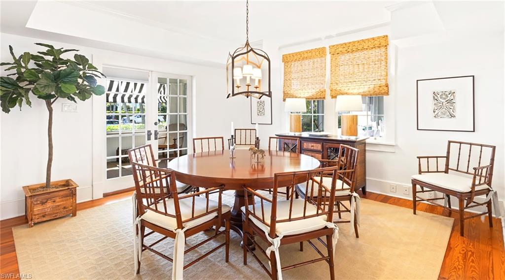 Dining area featuring light wood finished floors, french doors, and hanging lights