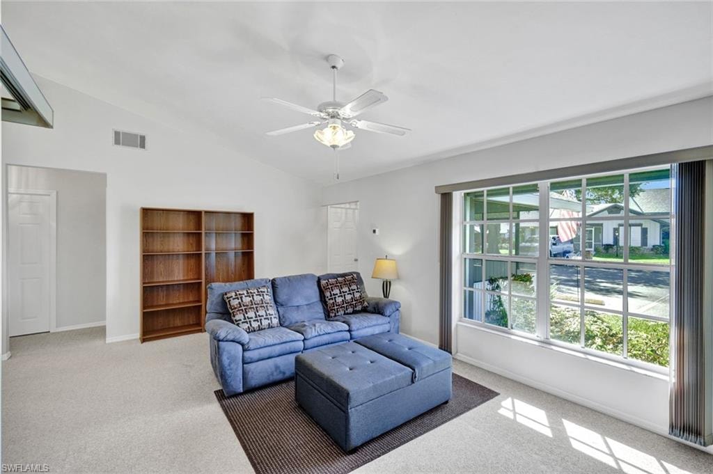 Living room with double windows, view of entry and hallway to bedrooms