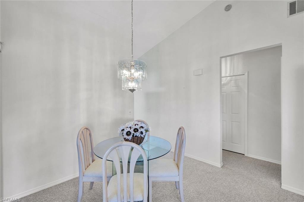 Chandeliered dining area with entry to kitchen and bedroom hallway