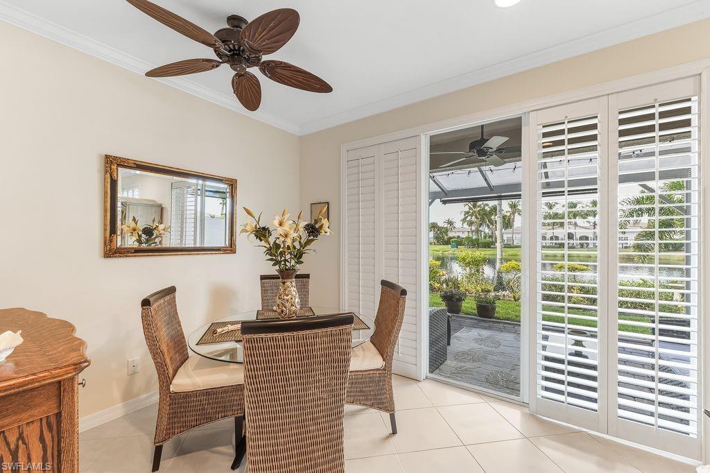 Dining Area off the Living Room with light tiled floors, crown molding, and a ceiling fan