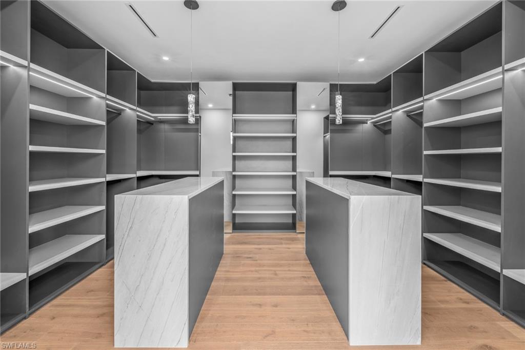 Spacious closet featuring light wood-style flooring