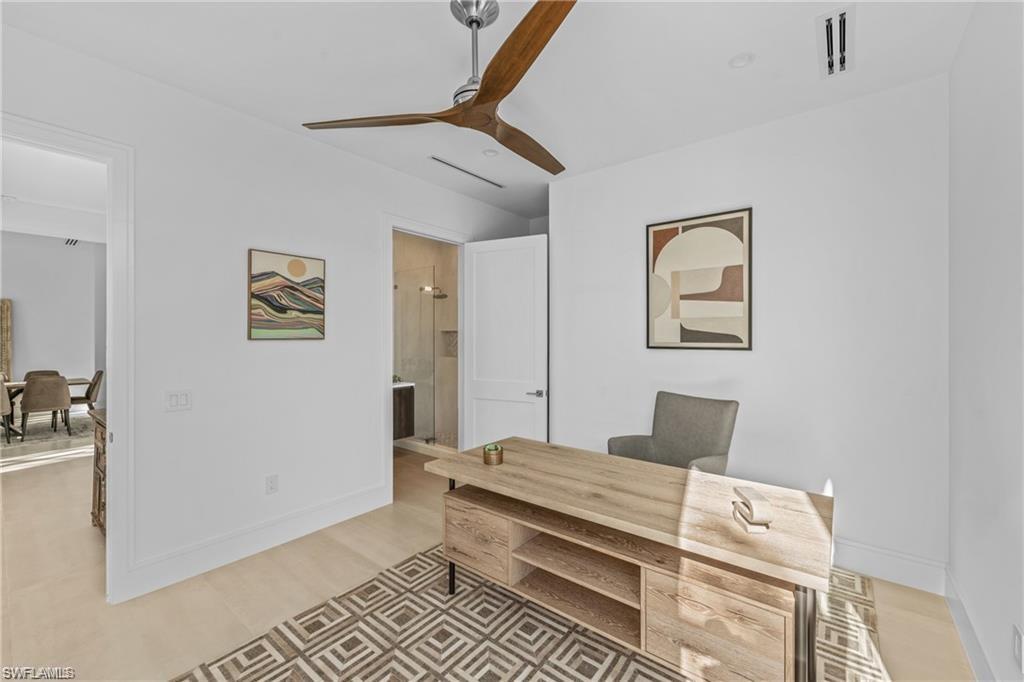 Home office with a ceiling fan and light wood-style floors