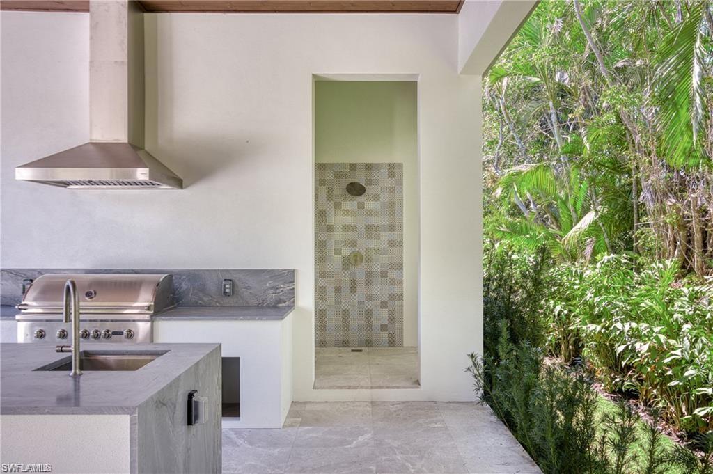 View of patio with an outdoor kitchen and a sink