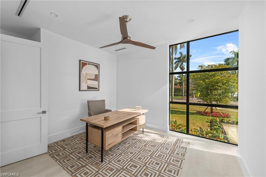 Office featuring floor to ceiling windows and ceiling fan