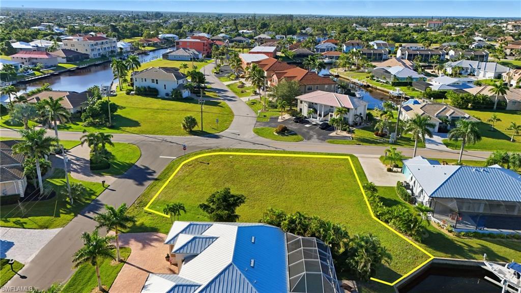 Aerial perspective of suburban area featuring property parcel outlined and a large body of water