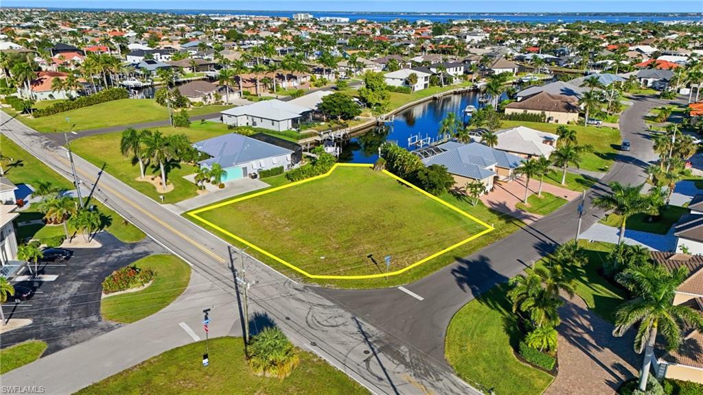 Aerial perspective of suburban area with property boundaries highlighted and a large body of water