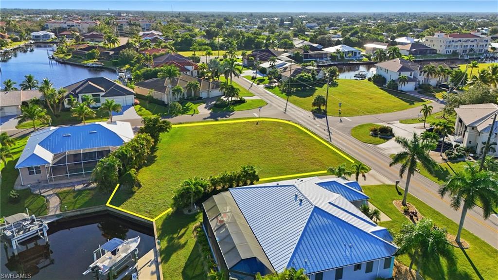 Aerial view of residential area with property parcel outlined and a nearby body of water