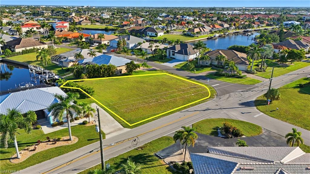 Aerial perspective of suburban area with property boundaries highlighted and a large body of water