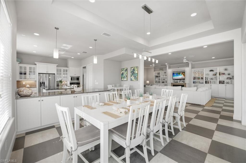 Dining space featuring recessed lighting, a tray ceiling, and light floors