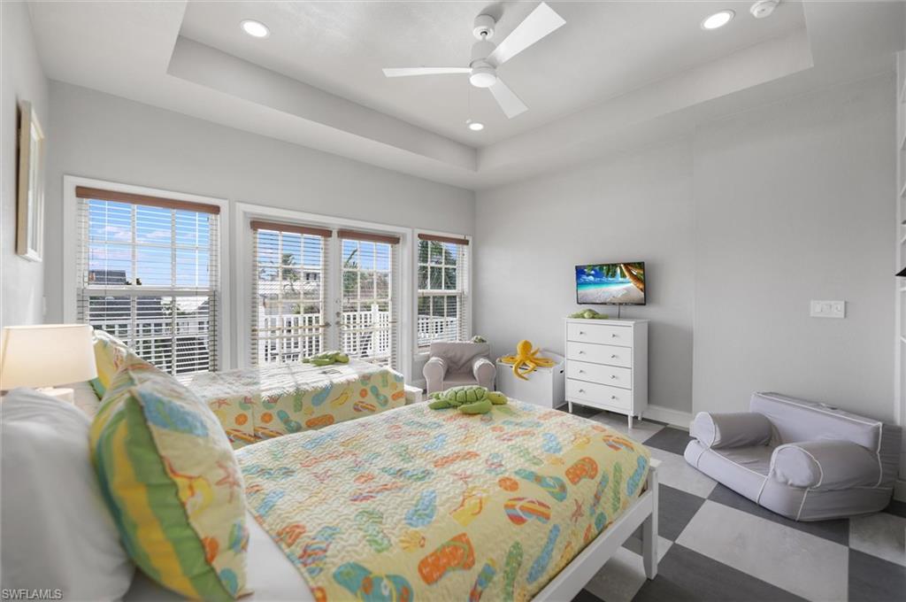 Bedroom featuring a tray ceiling, access to exterior, ceiling fan, and recessed lighting