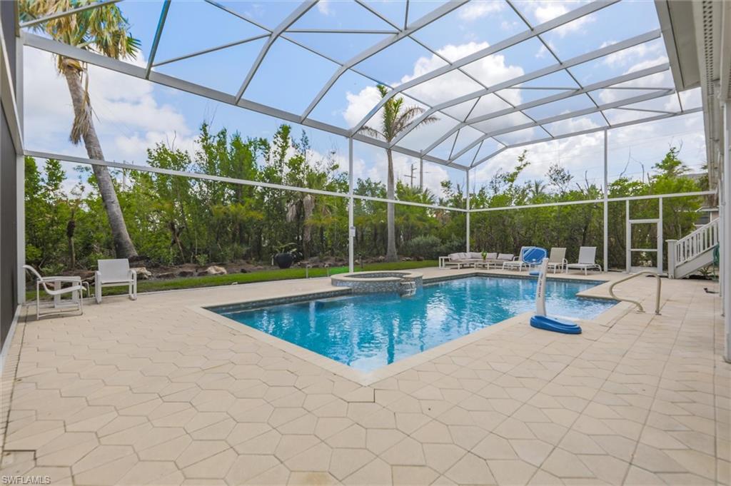 View of swimming pool with a patio, a lanai, and a pool with connected hot tub