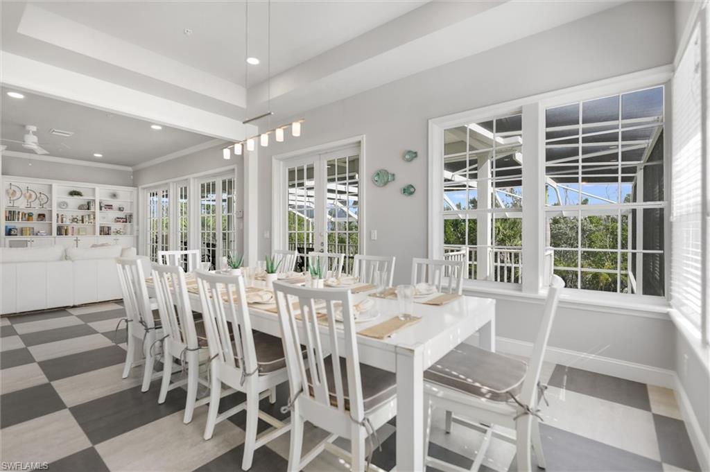Dining area with recessed lighting, a tray ceiling, and french doors