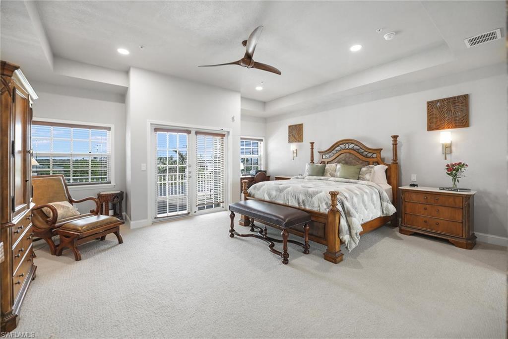 Bedroom with access to outside, carpet flooring, a raised ceiling, recessed lighting, and ceiling fan