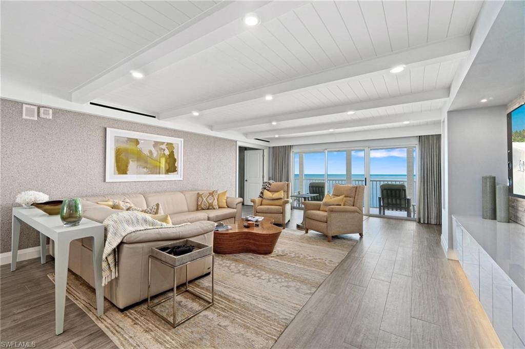 Living room with beam ceiling, light wood-style floors, and recessed lighting