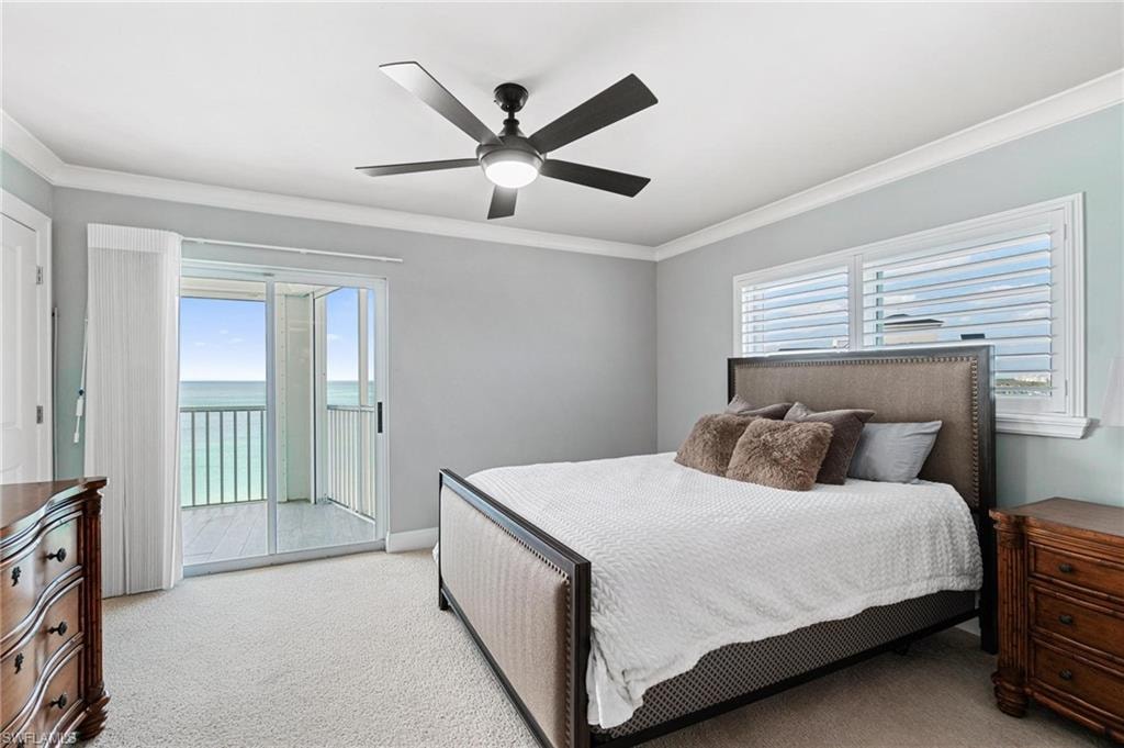 Bedroom with carpet floors, ornamental molding, multiple windows, a water view, and access to exterior