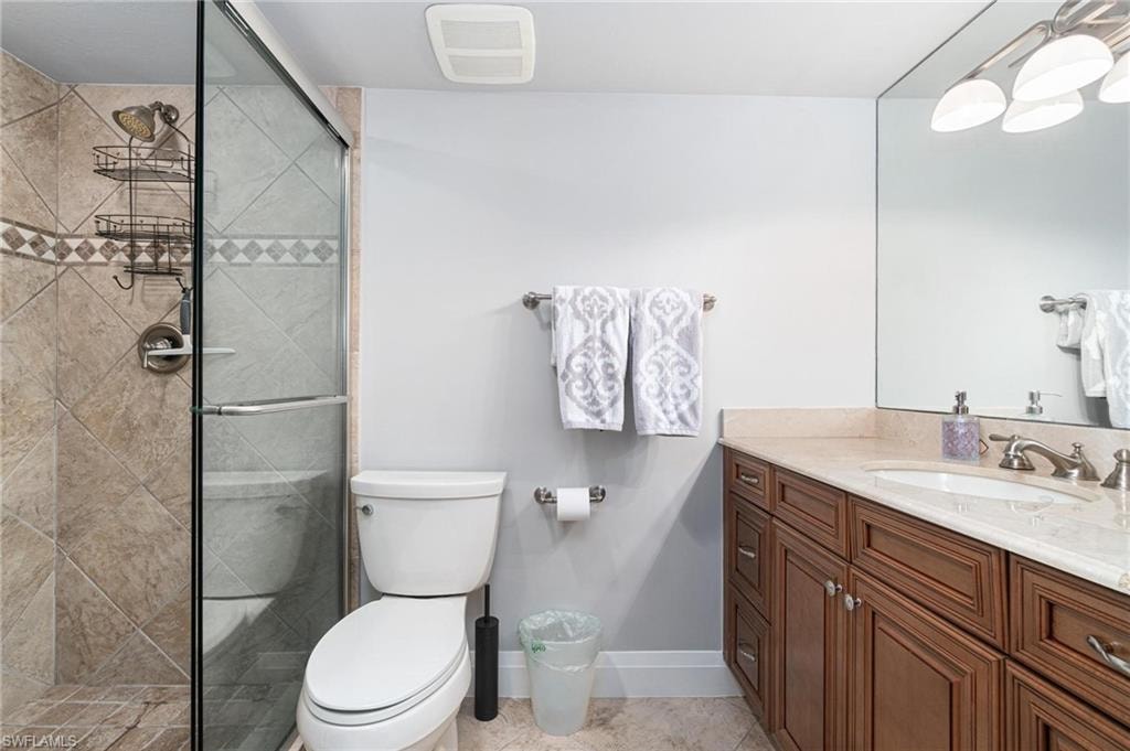 Full bathroom featuring a stall shower, vanity, and light tile patterned floors