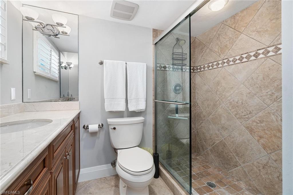 Bathroom with vanity, light tile patterned floors, and a shower stall