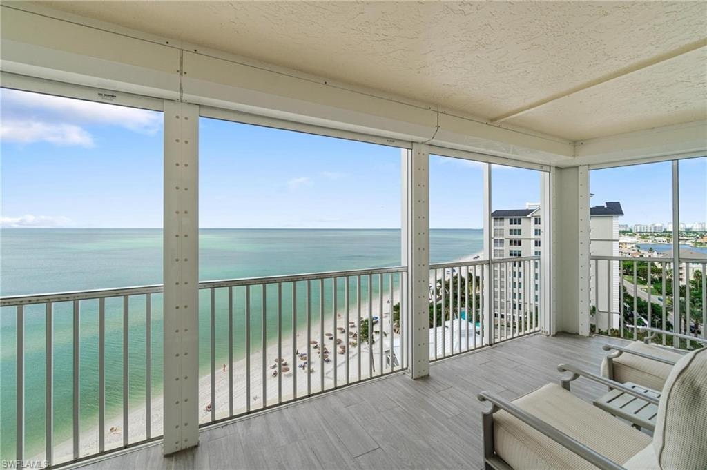 Sunroom / solarium with view of water and beach