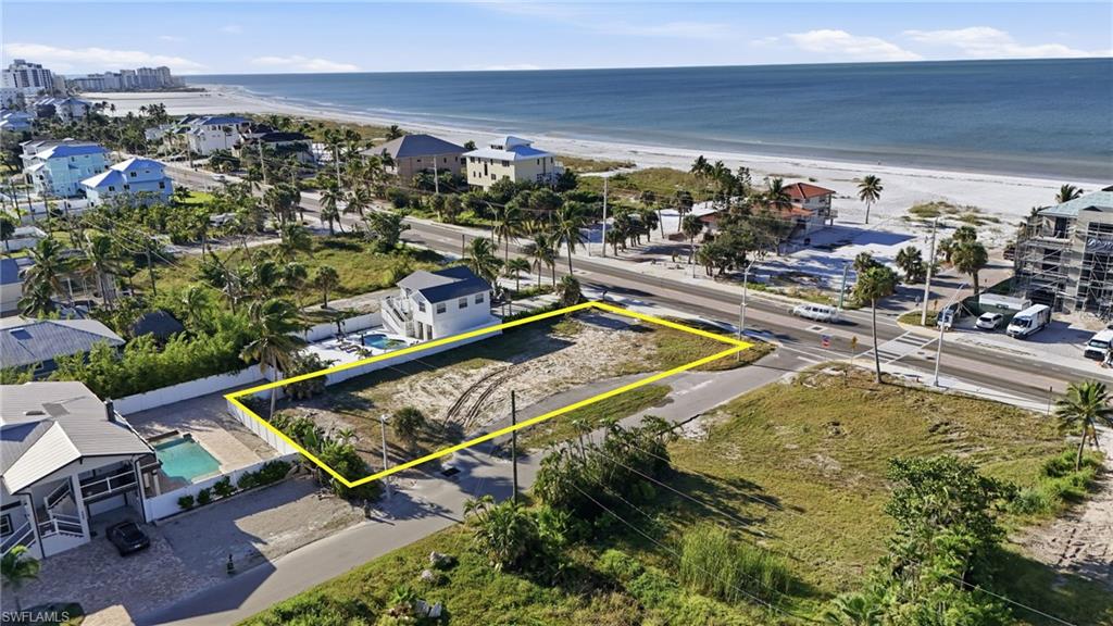 Aerial overview of property's location featuring property parcel outlined and waterfront with a beach - Virtually Edited Image
